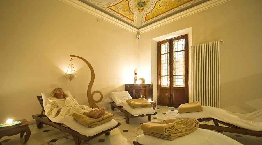 Una sala relax in una spa con lettini e soffitto decorato.